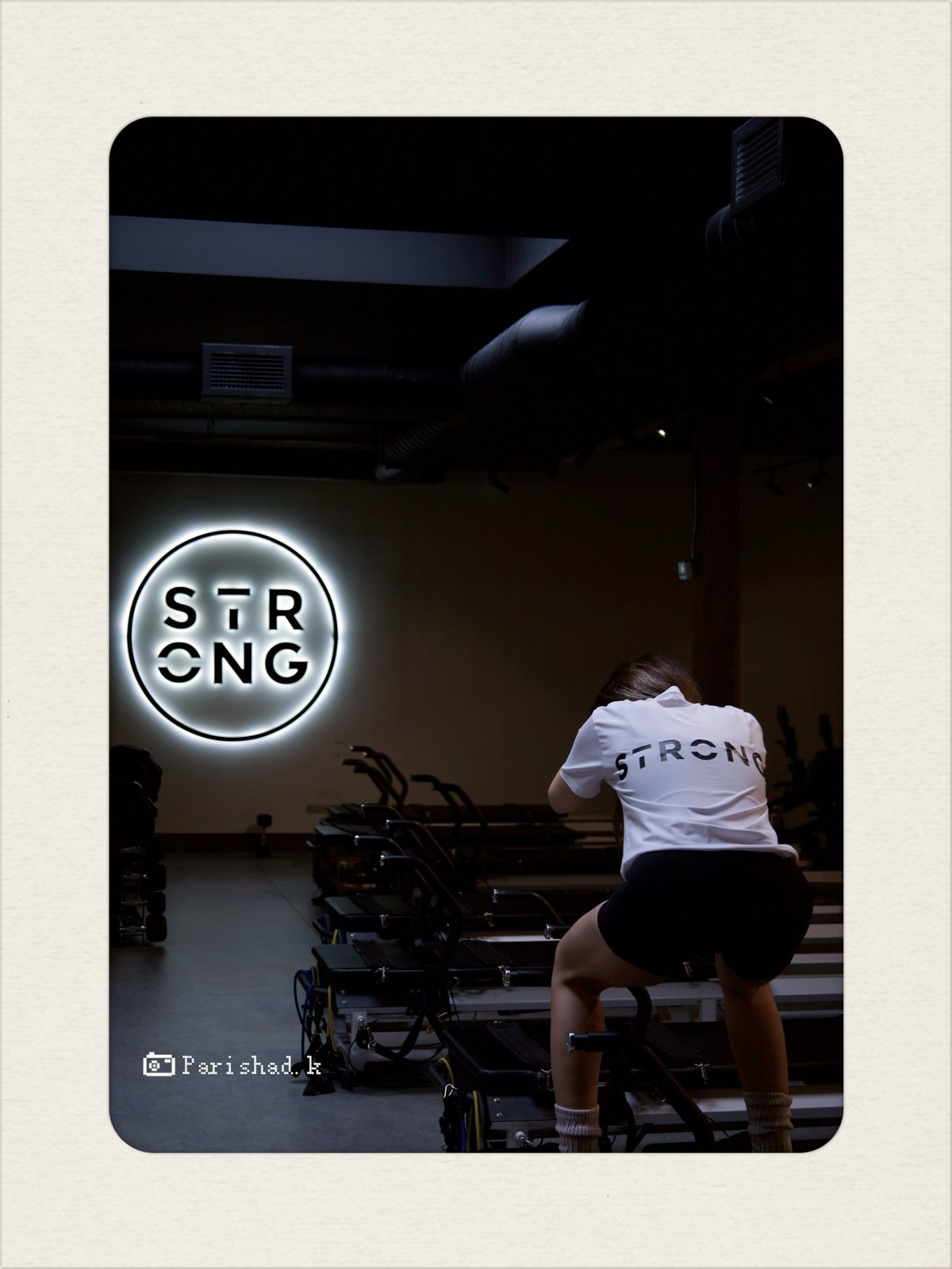 Client on a reformer in a STRONG tee