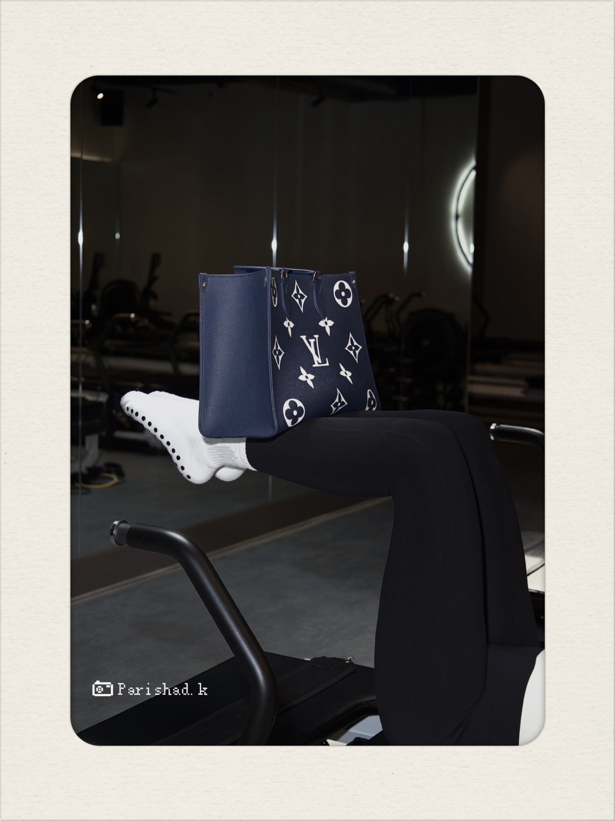 Louis Vuitton tote balanced on legs on a reformer